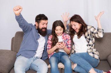 Evde mutlu bir aile. Küçük kız anne ve babasıyla smartphone kullanın. Aile mutlu ruh hali ile. Mutlu aile selfie. Sakallı erkek ve kadın kızı çocuk ile. Mutlu bir aile. Eğleniyor