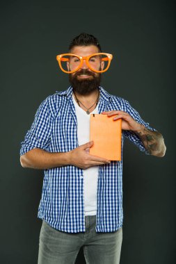 Kitap kurdu. Kitap nerd süslü gözlük takıyorum. Kitap nerd çalışma. Üniversite erkek öğrenci ders notları ile. Adam ders kitabı ile parti bardaklarda sakallı