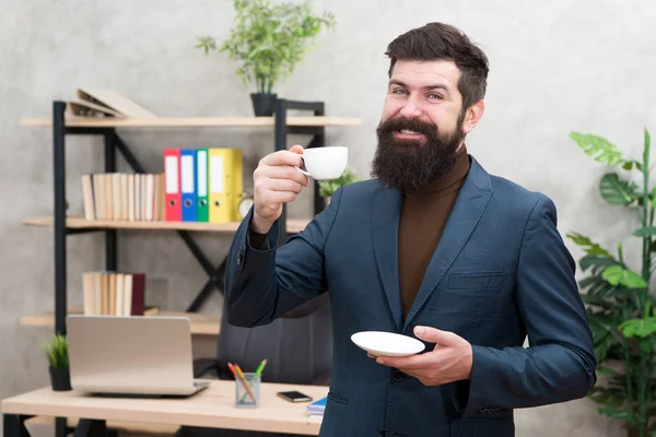 Beneficios de la cultura del café de oficina. Hombre barbudo empresario gerente empresario sostener taza de café. Relajado gerente superior bebiendo café. Jefe disfrutando de la bebida energética. Trabajador empezar el día con café caliente — Foto de Stock