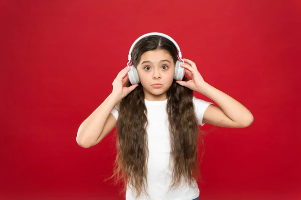 Τι είναι όλα αυτό περίπου. Μικρό κορίτσι φορώντας στερεοφωνικά ακουστικά. Ανεμιστήρας χαριτωμένο μουσική με ασύρματο ακουστικό. Μικρό παιδί χρησιμοποιώντας τεχνολογία για ψυχαγωγία ή την εκπαίδευση. Κοριτσάκι, ακούγοντας μουσική — Φωτογραφία Αρχείου