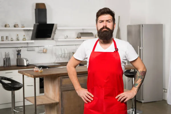 Hoe u kunt koken thuis in gewoonte. Man bebaarde hipster rode schort staan in de keuken. Keuken meubels te slaan. Koken in de nieuwe keuken. Culinaire inspiratie nodig. Weekend begint vanaf smakelijk ontbijt — Stockfoto