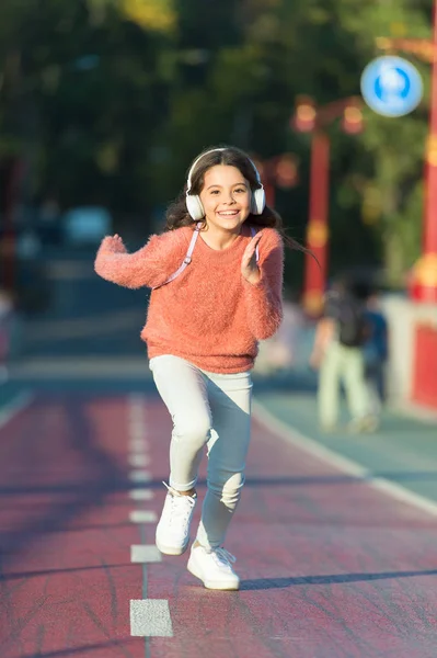 Dívka se sluchátky. Malé dítě si aktivitu. Kid, chůze, běh v parku poslech hudby. Hudba mě naplňuje energií. Užijte si procházku s oblíbenou hudbou ve sluchátkách. Seznam stop pro aktivní den — Stock fotografie
