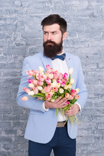 Levamos flores pessoalmente. Um presente de primavera. Homem barbudo hipster com flores. Com amor. férias internacionais. Dia das mulheres. 8 de Março. Homem barbudo com buquê de primavera tulipa. Hora da Primavera. desfrutando primavera — Fotografia de Stock