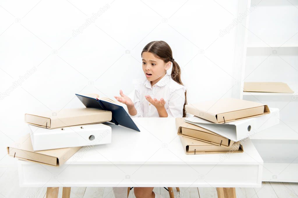 Oh no, the text is too long. Schoolgirl reading school book at desk. Little girl reading lesson book in school. Small school child have literature lesson. Adorable pupil develop reading skills