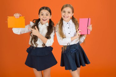 Kitap kapağı, işaret parmağı. Çalışma kitaplarını yazmak için küçük kızlarla. Şirin kız öğrenciler ders kitapları tutarak. Okul çocukları kitap okumak öğrenmek. Küçük çocuklar ile okul diaries notlar yapmak için