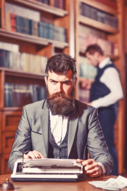 Raflardan arka plan üzerinde yeni bir kitap üzerinde çalışan yazar.