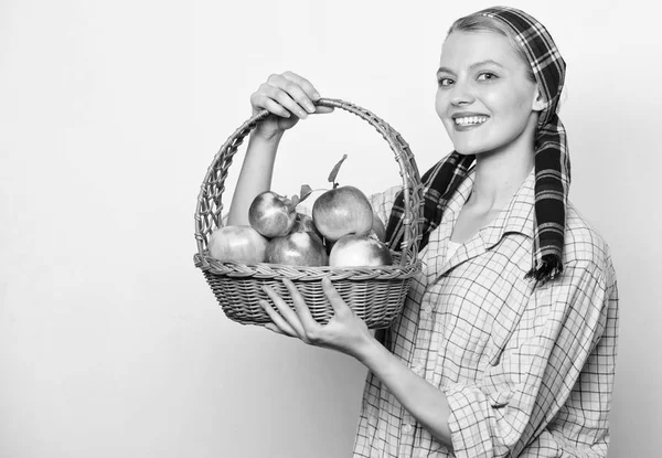 Lady farmer or gardener proud of her harvest. Natural gifts concept. Woman cheerful carry basket with natural fruits. Woman gardener rustic style hold basket with apples harvest on light background