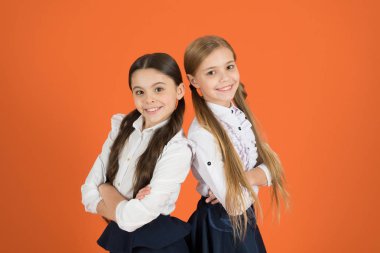Geleneksel siyah ve beyaz. Küçük kızlar okul üniforması giyiyor. Okul çocukları ile moda ileri bakmak. Şirin kız öğrenciler. Pigtails küçük kızlar okul için giyinmiş. Geri okul moda