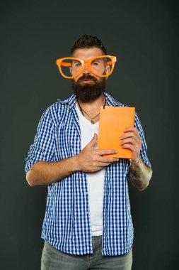 İnek yeni cool olduğunu. Kitap nerd çalışma. Kitap nerd süslü gözlük takıyorum. Üniversite erkek öğrenci ders notları ile. Adam ders kitabı ile parti bardaklarda sakallı
