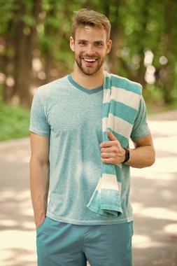Adam atlet çalışan açık doğa arka plan sonra havlu ile. Atletik adam parkta eğitim. Spor ve egzersiz kavramı. Atlet spor giysiler ve havlu eğitim. Runner egzersiz güneşli