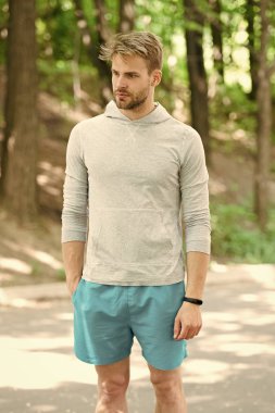 Sporcu pedometre gadget ile eğitim. Fitness izci kavramı. Atlet ile kıl fitness izci veya adım sayar. Adam atlet Spor donatımı, Doğa arka plan ile poz sıkı yüzünde