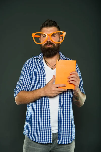 Nerd ist der neue Coole. Studie Nerd hält Buch. Buch-Nerd mit schicker Brille. männlicher Student mit Vorlesungsnotizen. Bärtiger Mann mit Parteibrille und Lehrbuch — Stockfoto