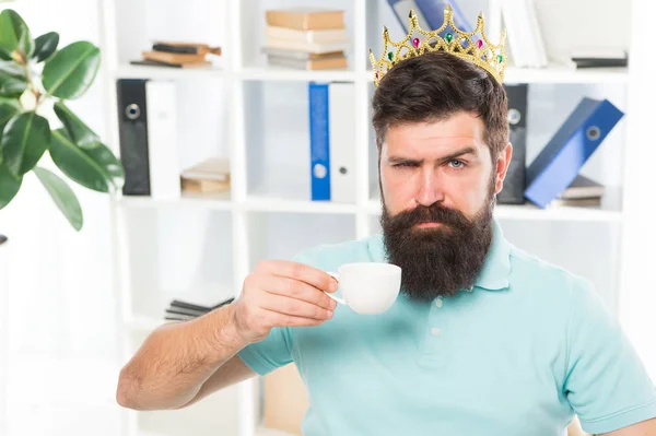 Head of department. Head office concept. Man bearded manager businessman entrepreneur wear golden crown on head. Relaxed top manager drinking coffee. Confident boss enjoying his glory. King of office