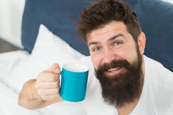 Accro à la caféine. Le café vous remplit d'énergie. Bon gay commence par une tasse de café. Le café affecte le corps. Homme beau hipster détente sur le lit avec tasse de café. Habitudes et rituels définissent la personnalité — Photo