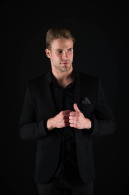 Adam çekici emin modeli. Onun tarzı kendine güvenen. Karanlık giysili adam. Raslantı yakışıklı. Adam yakışıklı bakımlı maço siyah arka plan üzerine. Duygu kendinden emin. Erkek güzellik ve erkeklik