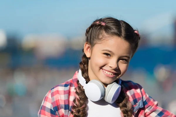 For enjoying sound of music. Adorable music fan with wireless headset on neck. Little child using technology for listening music. Small girl with stereo headphones. Music education