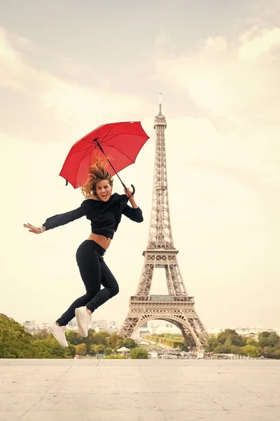 Άλμα γυναίκα με ομπρέλα μόδας. Ευτυχισμένη γυναίκα ταξίδια στο Παρίσι, Γαλλία. Παριζιάνικο απομονώνονται σε λευκό φόντο. Κορίτσι ομορφιά ματιά σε πύργο του Άιφελ. Ταξιδεύοντας και περιπλάνησης. Απολαύστε τις καλοκαιρινές διακοπές — Φωτογραφία Αρχείου