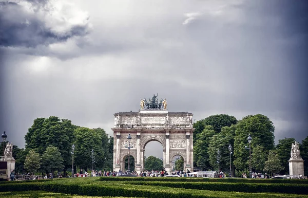 París, Francia - 02 de junio de 2017: Arco del Triunfo del Carrousel en el Palacio del Louvre. Monumento al arco y árboles verdes en el cielo azul. Símbolo arquitectónico de victoria por la paz y la fama. Vacaciones en la capital francesa — Foto de Stock