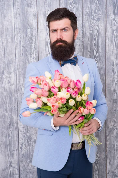 Mann gepflegt tragen Smoking Fliege halten Blumenstrauß. laden sie zum Dating ein. Romantiker mit Blumen. Romantisches Geschenk. Macho macht sich bereit für romantisches Date. Warten auf Liebling. Tulpen für den Liebsten — Stockfoto