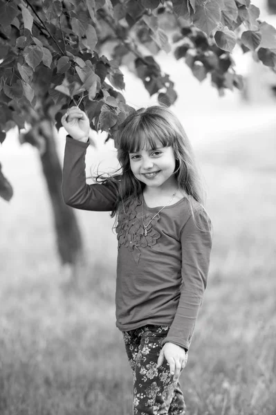 Linda menina sorridente em pé perto de árvore grande — Fotografia de Stock