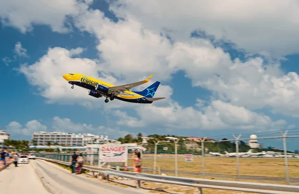 Philipsburg, Sint Maarten - 13 de febrero de 2016: vuelo bajo plano sobre la playa del maho. Vuelo en avión aterriza en el cielo azul nublado. Avión en nubes soleadas. Vacaciones en la playa del Caribe. Wanderlust, viaje y viaje — Foto de Stock