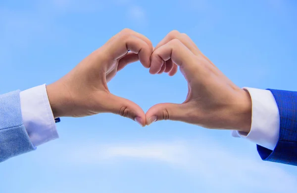 Love symbol koncept. Händer satt ihop i hjärtat formen blå himmel bakgrund. Manliga händer i hjärtat formen gest symbol för kärlek och romantik. Hand hjärtat gest bildar formen med fingrarna — Stockfoto