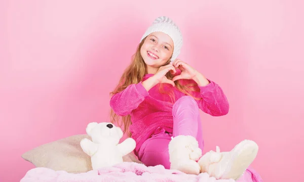 Kid cute girl play with soft toy teddy bear pink background. Child small girl playful hold teddy bear plush toy. Unique attachments to stuffed animals. Teddy bears improve psychological wellbeing