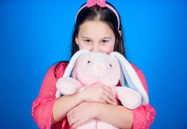 Barn leende spela bunny leksak. Lycklig barndom. Få i påsk anda. Bunny öron tillbehör. Härlig lekfull kanin barn kramar mjuk leksak. Har välsignat påsk. Kaninflicka med söt leksak på blå bakgrund — Stockfoto