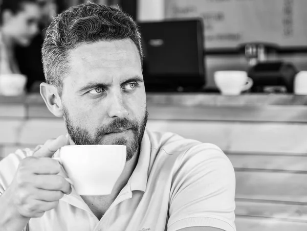 Börja dagen med stor kopp kaffe. Mannen skäggig allvarligt ansikte behov energi kostnad. Traditionell fika café bakgrund. Koffein gör dig piggare. Seriös kille njuta av koffein drink närbild — Stockfoto