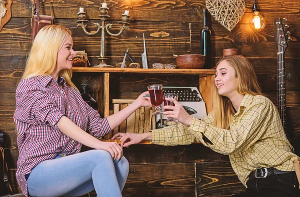 Chicas relajantes y beber vino caliente con especias. Amigos en caras sonrientes en ropa a cuadros celebrando. Concepto de amistad. Amigos en trajes casuales divirtiéndose mientras celebran con vino, interior de madera — Foto de Stock