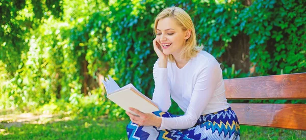 Meisje enthousiast over het boek blijven lezen. Het lezen van literatuur als hobby. Meisje zitten Bank ontspannen met een boek, groen achtergrond. Vrouw blond pauze ontspannen in park leesboek. Favoriete boek — Stockfoto