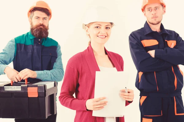 Woman and men in hard hats stand close as team. — Stock Photo
