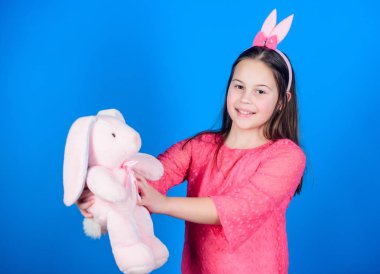 Mutlu çocukluk. Tavşan kulakları aksesuar. Güzel oynak bunny çocuk yumuşak oyuncak sarılmak. Tavşan kız şirin oyuncak üzerinde mavi arka plan ile. Çocuk gülümseyen oyun bunny oyuncak. Paskalya kutsadı. Paskalya ruhu içinde elde