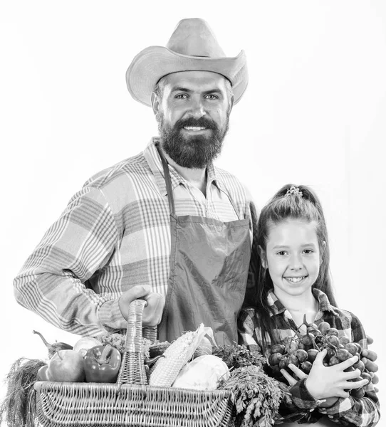 Father farmer or gardener with daughter hold basket harvest vegetables. Gardening and harvesting. Family farm organic vegetables. Man bearded rustic farmer with kid. Farmers family homegrown harvest