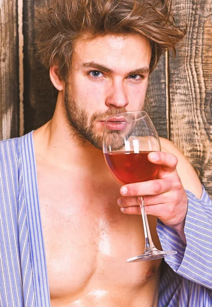 Drink wine and relax. Guy attractive relaxing with alcohol drink. Man sexy chest wet skin after bath hold wineglass. Bachelor enjoy wine after bath. Macho tousled hair degustate luxury wine