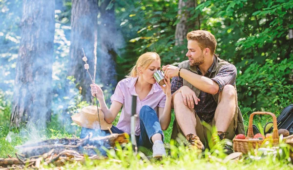 Food for hike and camping. Couple sit near bonfire eat snacks and drink. Couple in love camping forest hike. Hike snacks and beverages. Hike picnic. Couple take break to eat nature background