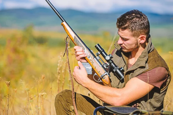 Jagdausstattungskonzept. Jäger khaki Kleidung bereit für die Jagd Natur Hintergrund. Jagdtrophäe. Jäger mit Gewehr auf der Suche nach Tier. Hobby und Freizeit der Jagd. Mann lädt Jagdgewehr — Stockfoto