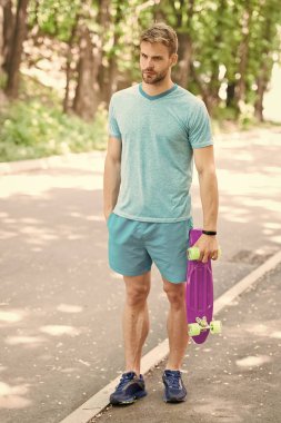 Hala çocukça. Adam penny Yönetim Kurulu, binmeye hazır taşır. Adam sakin yüz kuruş kurulu park doğa arka plan defocused, taşır. Adam kaykay ve sportif yaşam tarzı binmeyi seviyor. Hobi kavramı