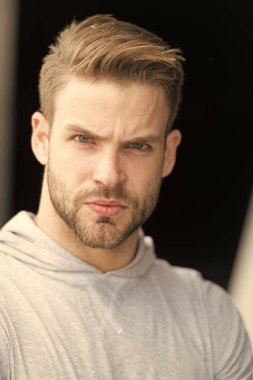 Metroseksüel kavram. Yakışıklıymış. Sakallı çekici adam görünüşü önemser. Adam ciddi, katı bir yüz, siyah arka plan, yakın çekim. Sakalsız adam yakışıklı ve havalı görünüyor.