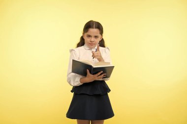 Daha iyi biliyorsun. Ev ödevi ile yapılan çocuk okul üniforma akıllı çocuk. Kız sevimli ciddi yüz sarı arka plan. Çocuk kız okul tek tip kıyafet kitap ve kalem tutar. Onay bilgi kavramı
