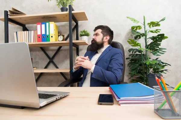 Pensando en el objetivo principal. Hombre barbudo jefe sentarse oficina con portátil. Gerente resolviendo problemas de negocios. Empresario a cargo de soluciones empresariales. Desarrollar una estrategia empresarial. Negocio riesgoso — Foto de Stock