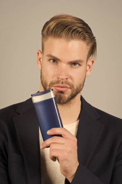 Şampuan şişesi ile iş adamı. Sakallı adam jel tüp tutun. Saç Bakımı ve cilt bakımı. Sabah Kuaförler Berber salonları veya berber dükkanı damat. Sağlık ve sağlık. Banyo veya duş için welness kozmetik