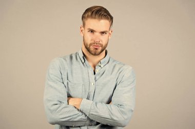 Sakallı adam tutun silah gri arka plan üzerinde geçti. Maço ile ciddi bir yüz. Her gün işten sonra yorgun. Ofis kıyafet. Casual tarzda. Güven ve karizma. Genç ve yakışıklı