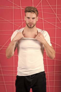 Sakallı ve çekici bir adam gömleğini yırtıyor. Erkeklik kavramı. Katı yüzlü, pembe geçmişli, kıllı bir adam. Sakallı ya da traşsız adam yakışıklı ve bakımlı görünüyor.