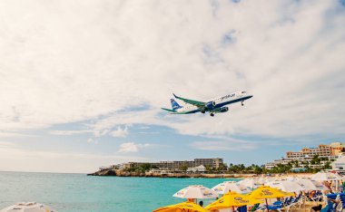 Philipsburg, Sint Maarten - 24 Ocak 2016: jet düşük uçmak uçuş maho plaj üzerinde. Bulutlu gökyüzü uçak karada. Uçak kişi mavi denizde. Yolculuk tutkusu, seyahat ve gezi. Caribbean Beach Tatil