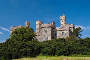 Yaz tatili: Lews Castle Stornoway, İngiltere. Castle ile mavi gökyüzü üzerinde yeşil ağaçlar. Victoria tarzı mimari ve tasarım. Simgesel Yapı ve cazibe