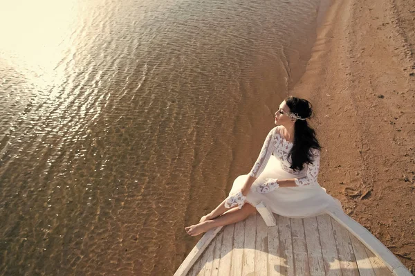 Novia adorable vestido de novia blanco día soleado sentarse en barco o barco. Playa de luna de miel. Las cosas cuentan para la boda en el extranjero. Ceremonia de boda playa mar. Consejos y consejos de expertos en bodas en el extranjero — Foto de Stock