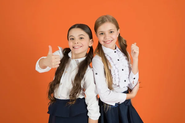 Pulgares para el nuevo estilo. Chicas elegantes en coletas vestidas para la escuela. Niñas usando uniforme escolar. Los niños de la escuela con una mirada hacia adelante de moda. Colegialas lindas. Volver a la moda escolar —  Fotos de Stock