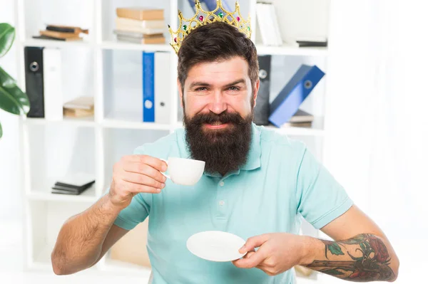 Trabajador feliz empleado. hombre de negocios feliz en la corona de oro. Un empleado feliz bebe café. Lugar de trabajo del jefe. Barbudo en la oficina de negocios. jefe y empleado. compromiso de los empleados. Bienvenida. trabajador feliz — Foto de Stock