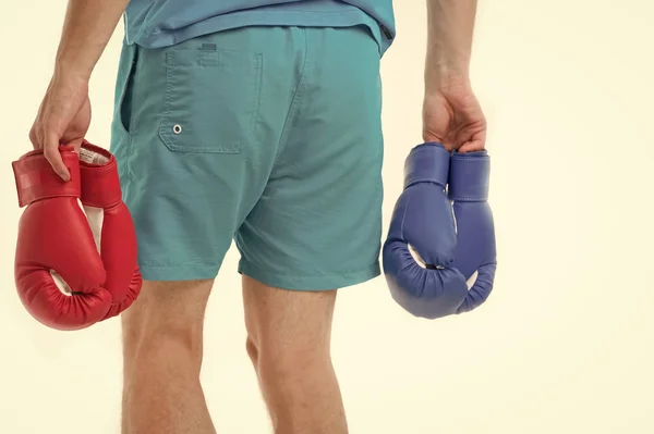 Ищу оппонента. Человек в шортах носит две пары боксерских перчаток с изолированным белым фоном. Оборудование профессиональный спортсмен. Профессиональное оборудование бокс. Боксерские перчатки — стоковое фото